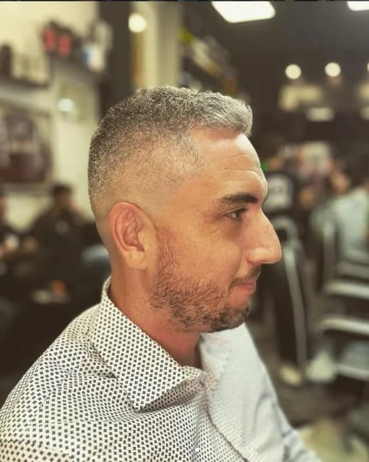 Sfumatura e barba curata su capelli brizzolati, di profilo